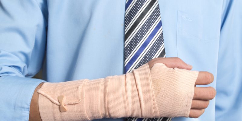 Broken arm on man with tie to represent car accident law by David H. Kaplan