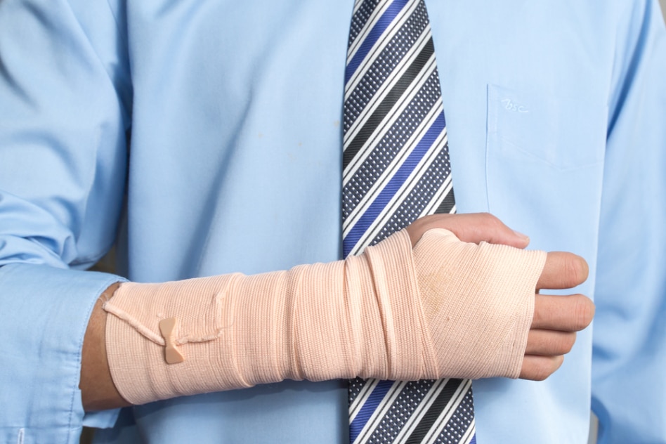 Broken arm on man with tie to represent car accident law by David H. Kaplan